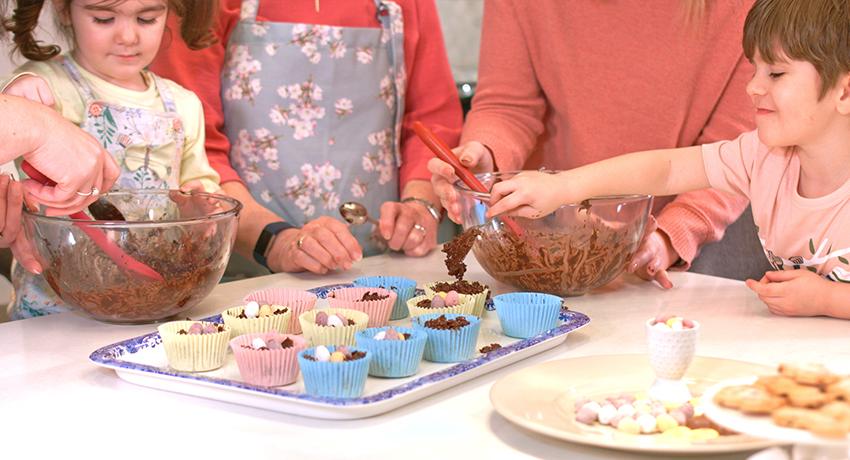 Children decorating Easter egg nest cakes